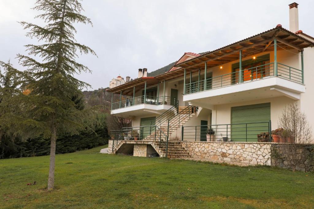a large white house with a stone wall at Country Home Giannaras in Piána