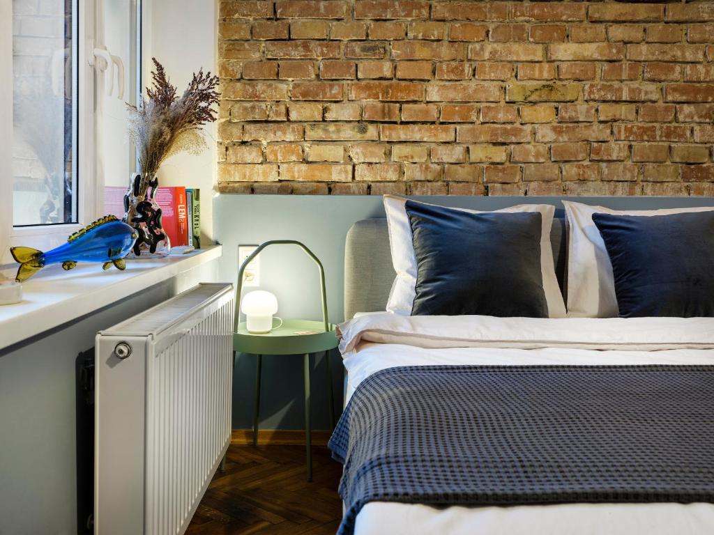 una camera con letto e muro di mattoni di Silent blue apartment / Kochanowskigo St a Cracovia