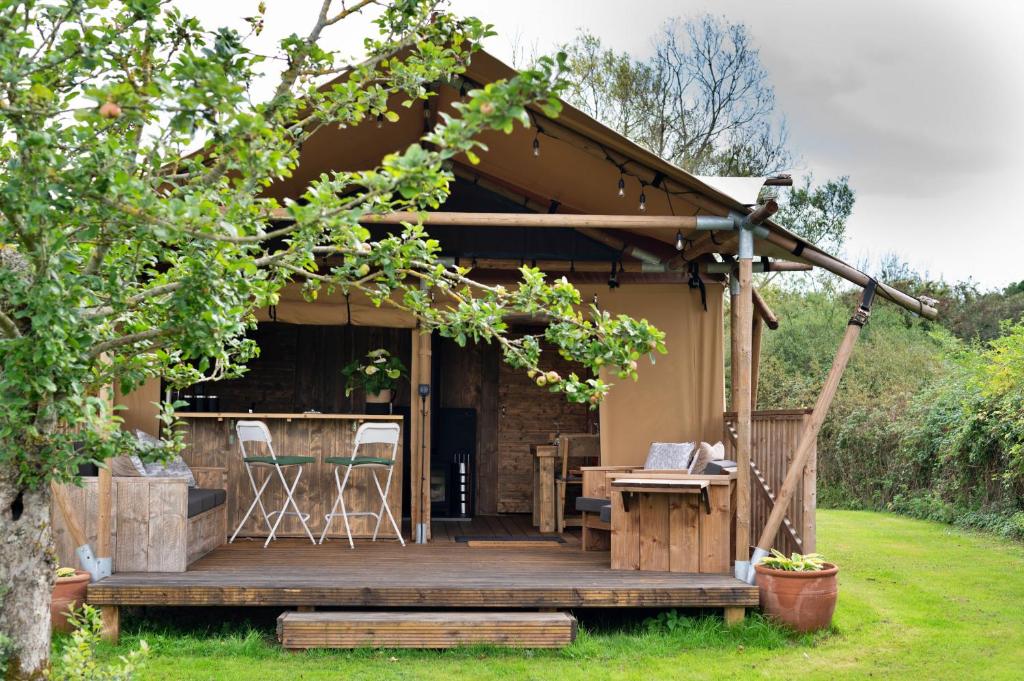 ein Haus mit einer Holzterrasse im Hof in der Unterkunft Finest Retreats - Rusty Lane, Safari Lodge in Seend