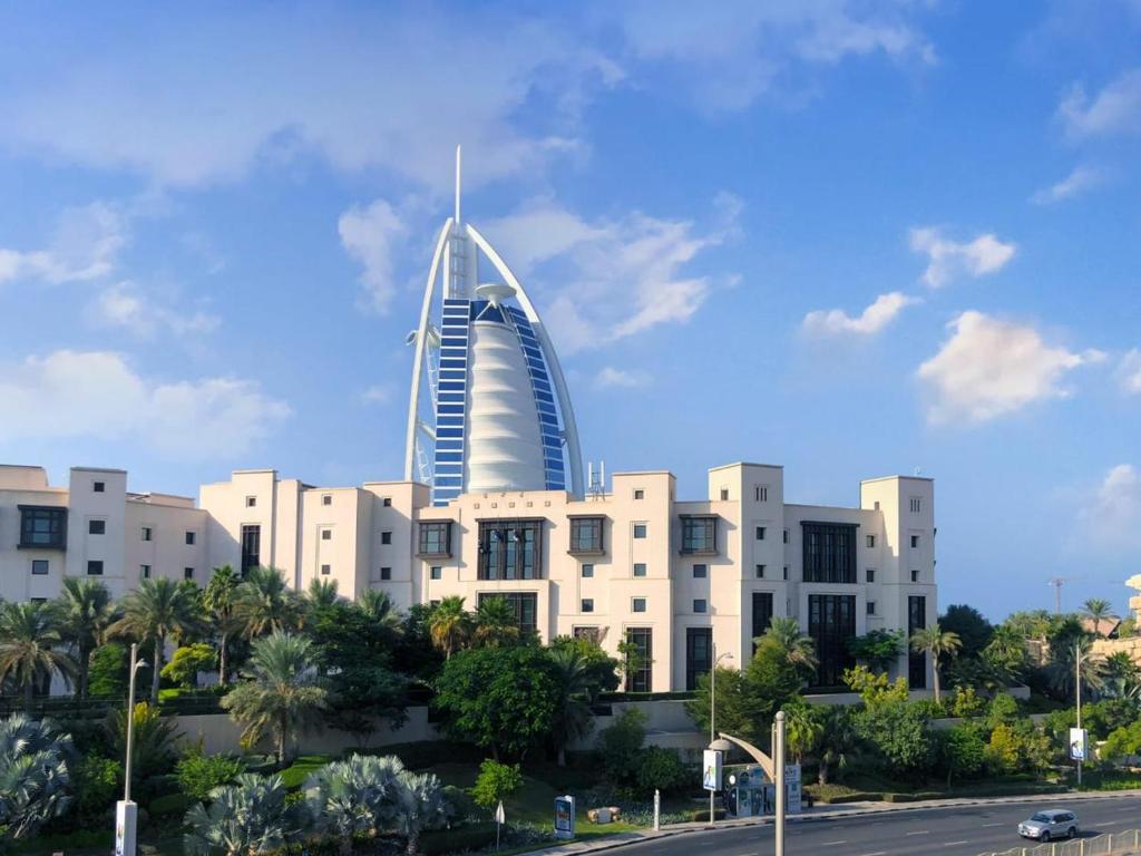 a large building with a tall skyscraper at Madinat Jumeirah Living in Dubai