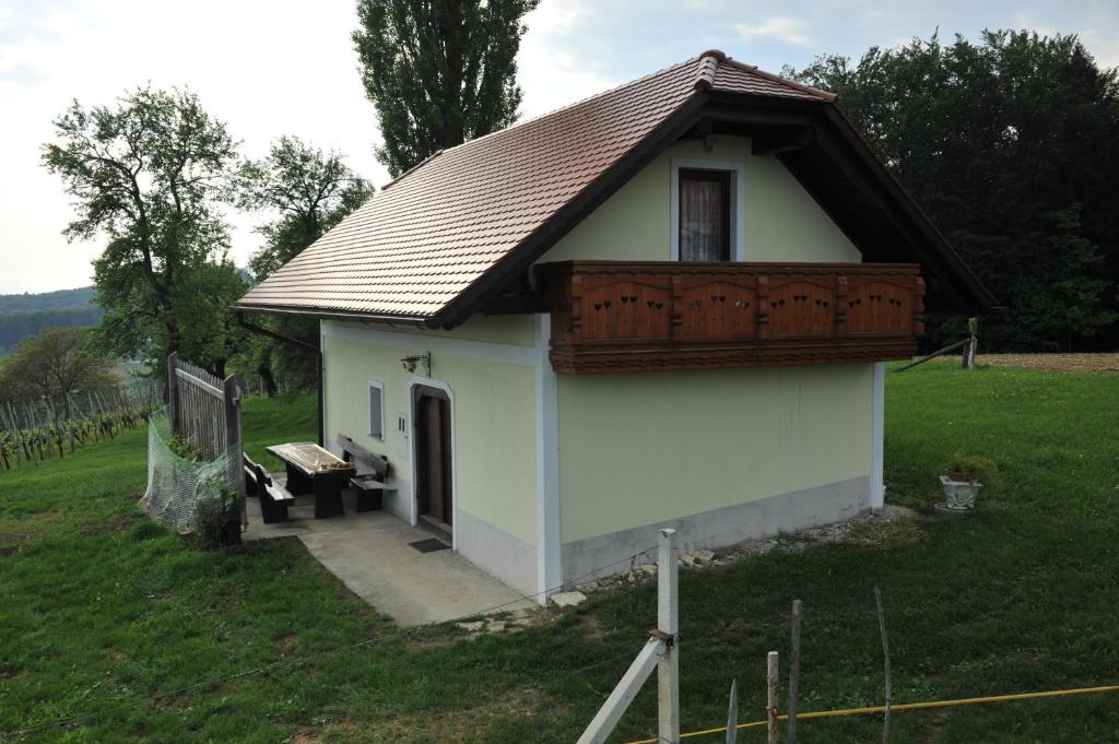 un pequeño edificio blanco con techo marrón en Vineyard Cottage Keglic, en Šmarje pri Jelšah