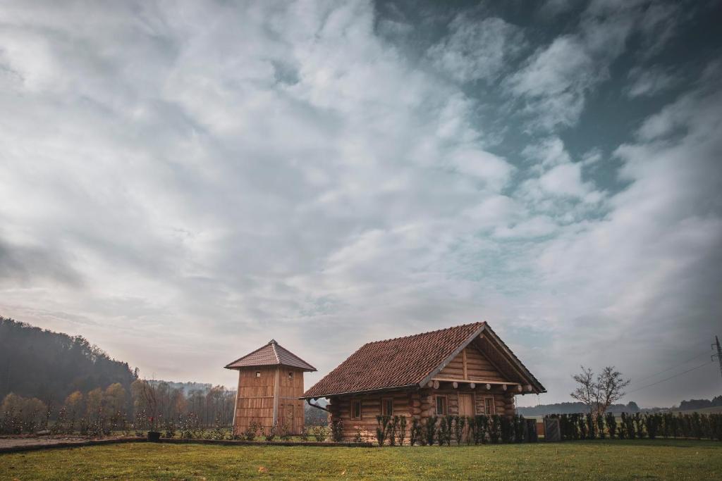 a wooden house in a field under a cloudy sky at Hiska Ulala in Dob