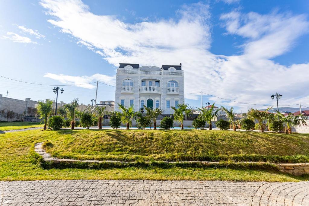 un gran edificio blanco con árboles delante de él en Shindisi Residence Boutique Villa en Tiflis