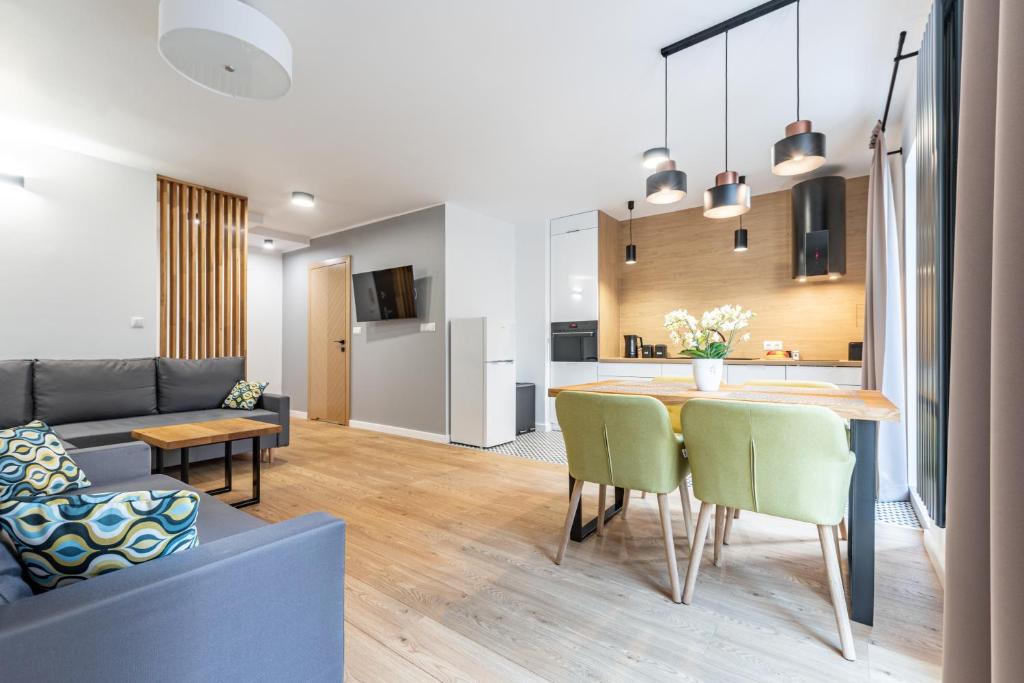 a living room and kitchen with a table and a couch at ApartSatiDeluxe in Pasłęk