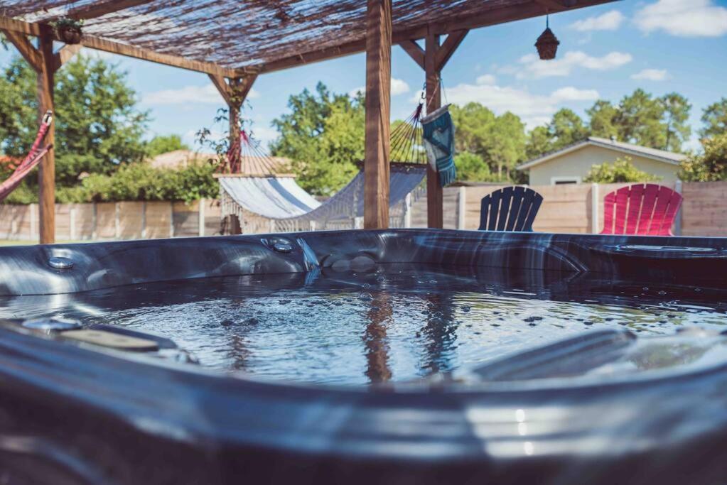 einen Pool mit Wasser und zwei Stühlen im Hinterhof in der Unterkunft Frenchy home☆ piscine ☆spa☆ bassin d’arcachon in Mios