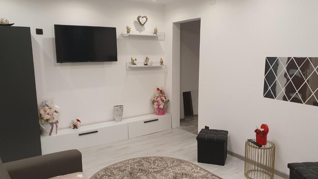 a living room with a flat screen tv on the wall at Apartament Ella ,wifi inclus la Straja ,Lupeni ! in Lupeni