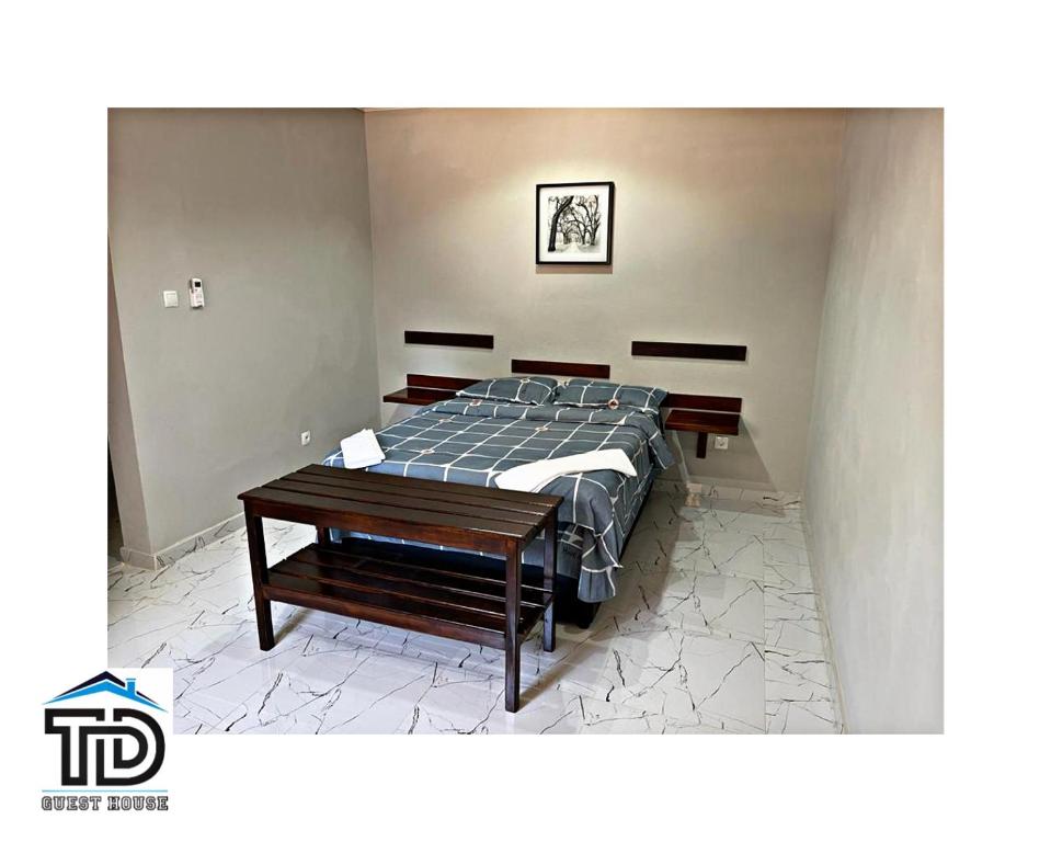 a bedroom with a bed and a wooden table at TD Guest House 5 Lite in Chimoio