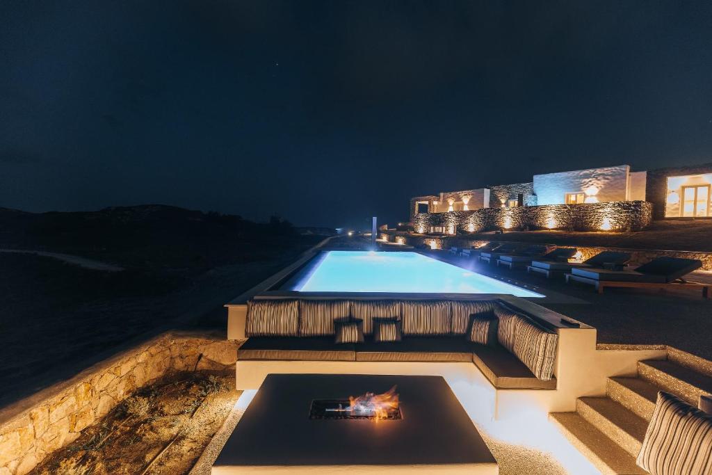 a swimming pool with a fire in it at night at Ventus di Milo in Adamas