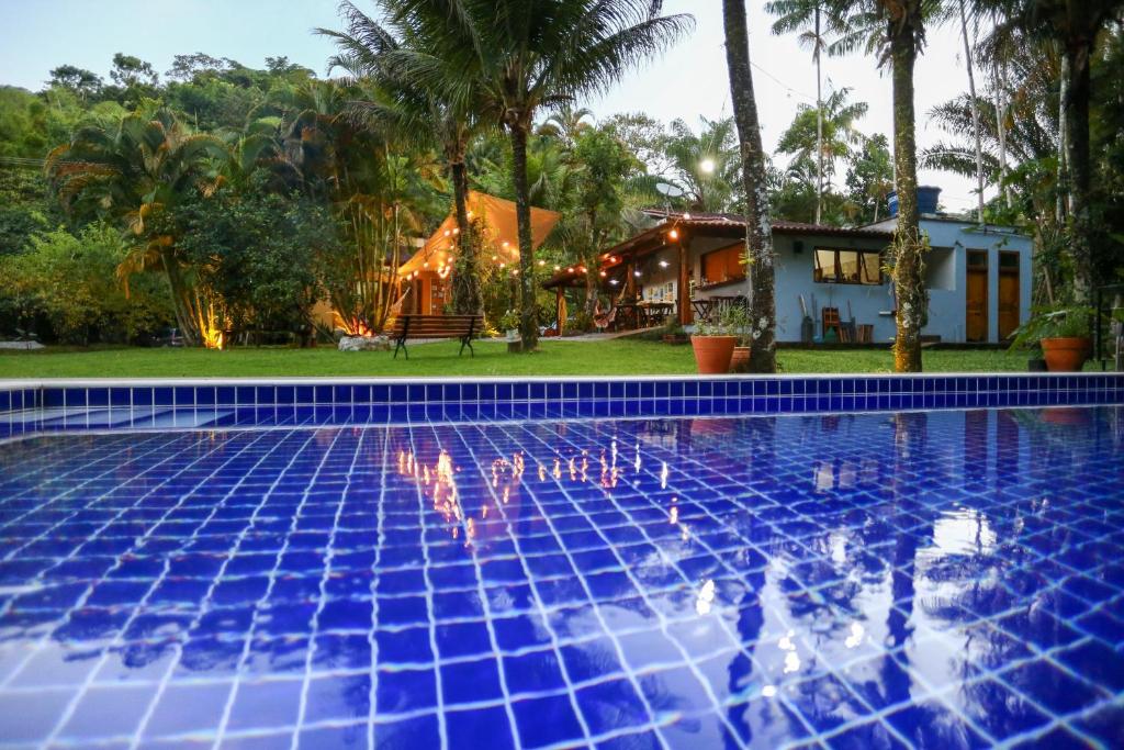 uma piscina em frente a uma casa com palmeiras em Casa Park em Paraty