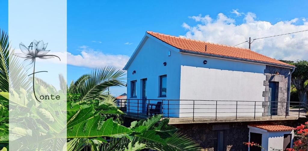 ein blau-weißes Haus mit einem Balkon in der Unterkunft A Fonte in Santo António