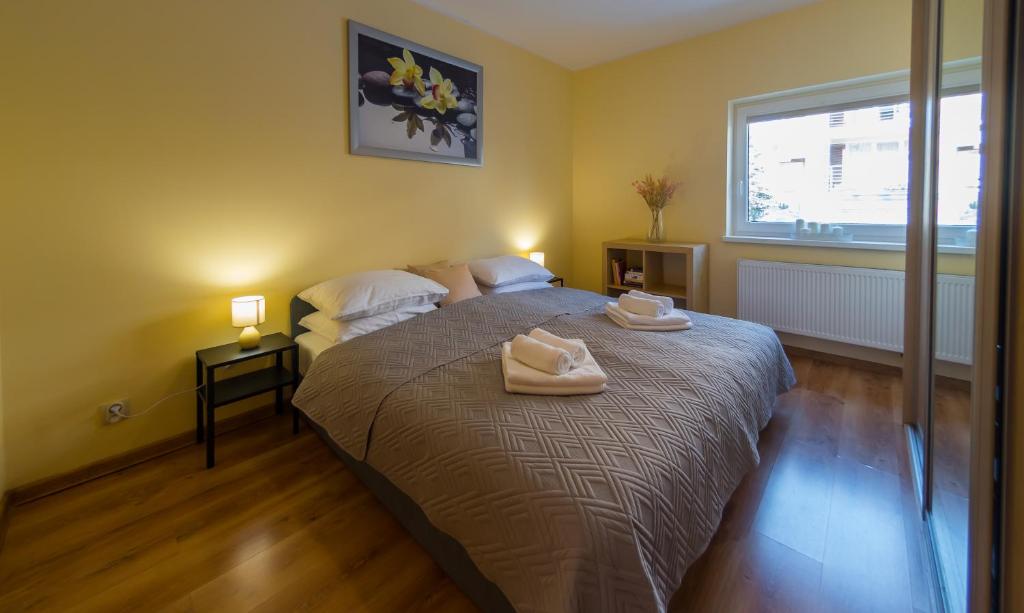sypialnia z łóżkiem i dwoma ręcznikami na nim w obiekcie Komfortowy Apartament w centrum Ustronia w Ustroniu