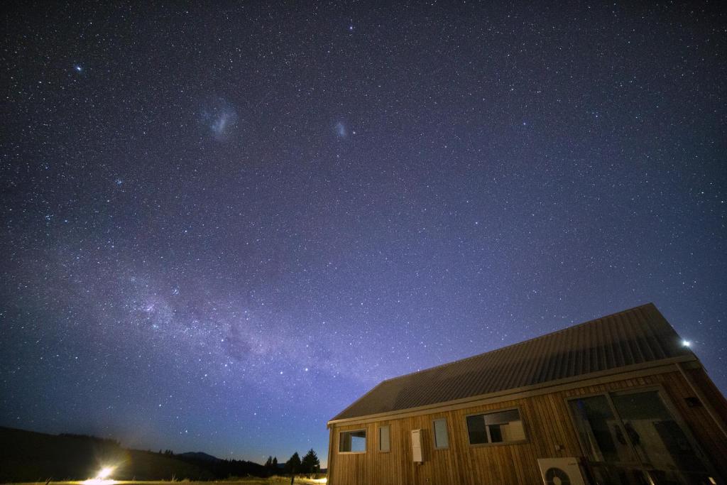 a cabin under a starry sky at night at Skyrim Lodge in Lake Tekapo