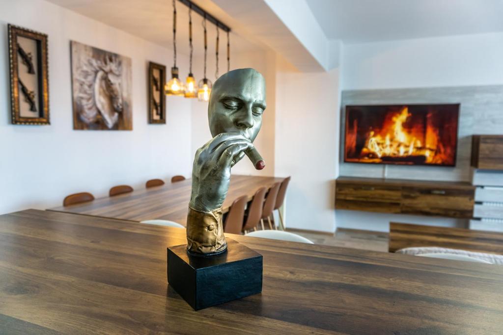 a statue of a man with his hand in a table at KOA - Sunset Penthouse in Braşov