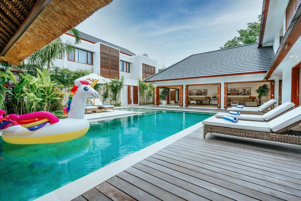 a pool with a inflatable unicorn in a house at Vienna Villas in Seminyak