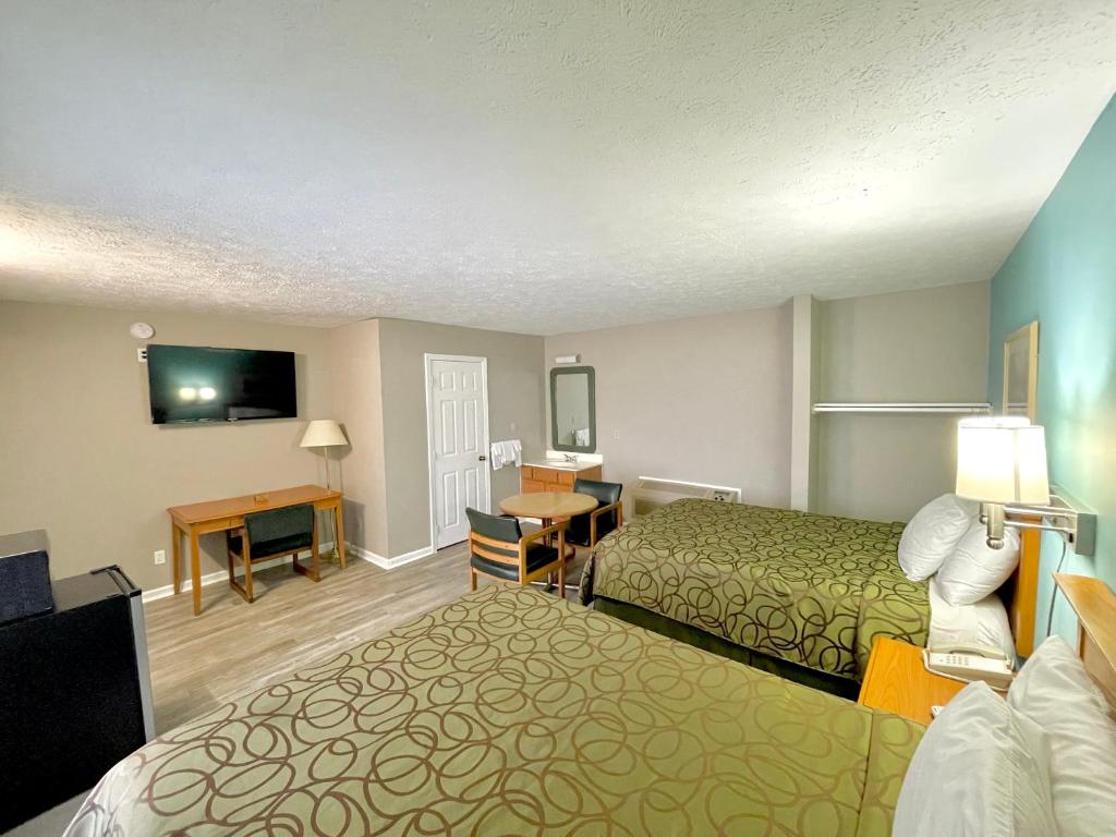 Cette chambre comprend deux lits et une télévision. dans l'établissement Overton Motel, à Livingston