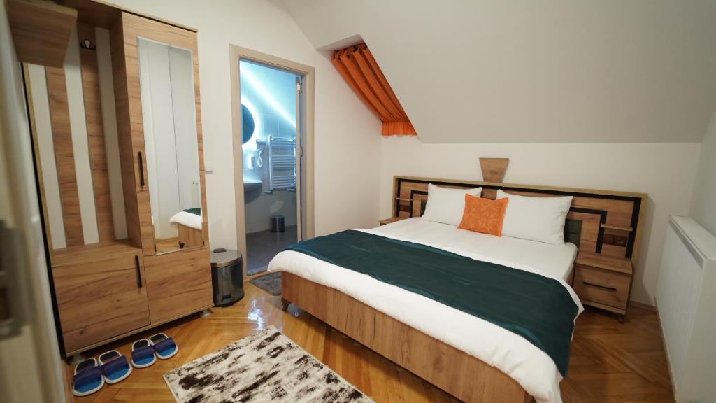 sypialnia z łóżkiem i dużym oknem w obiekcie Madigan's Hotel w mieście Kosovo Polje