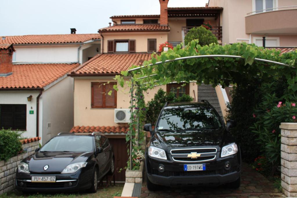 two cars parked in front of a house at Family Friendly Apartments in Pula