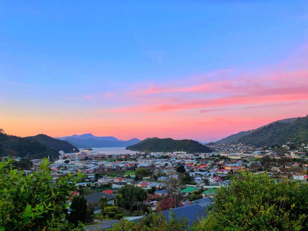 a view of a city at sunset at Picton Hilltop Apartment in Picton