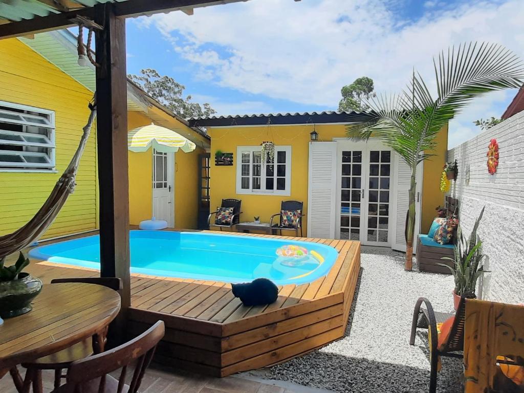 een achtertuin met een zwembad en een huis bij Villacasamarela mini casinhas de hospedes Rio vermelho in Florianópolis