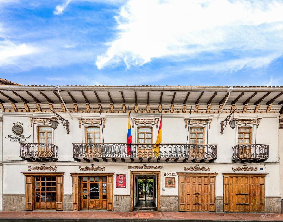 un edificio con 2 banderas en un balcón en Hotel Inca Real, en Cuenca