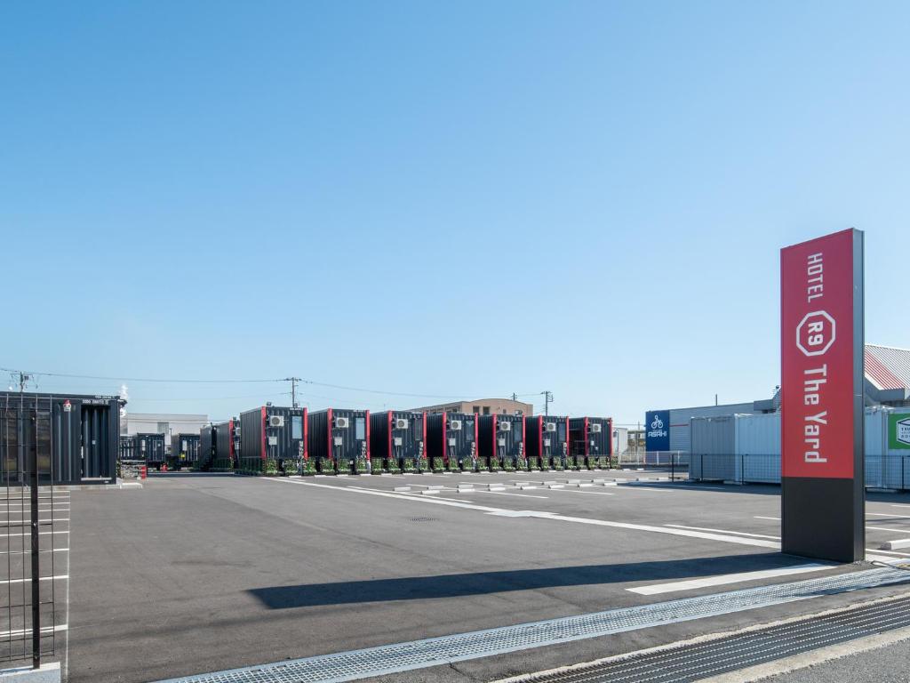 een lege parkeerplaats met een bord in het midden bij HOTEL R9 The Yard Kamisu in Kamisu