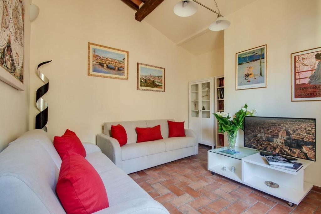un soggiorno con divano bianco e TV di Apartments Florence - Canto Dei Nelli a Firenze
