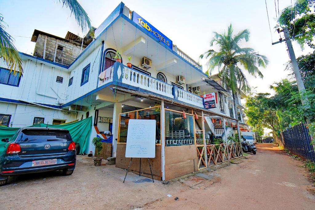 un bâtiment avec une voiture garée devant lui dans l'établissement FabExpress Antonio's, à Goa Velha
