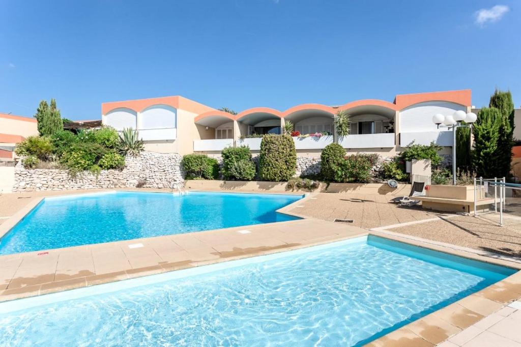 une piscine devant une maison dans l'établissement Résidence Le Cap des Terrasses - Studio 4 Personnes MAE-4837, à Cassis
