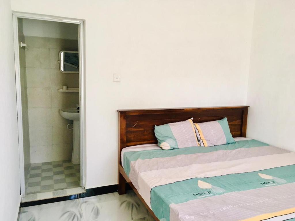 a small bedroom with two beds and a mirror at Sujeewa Holiday Resort Anuradhapura in Anuradhapura