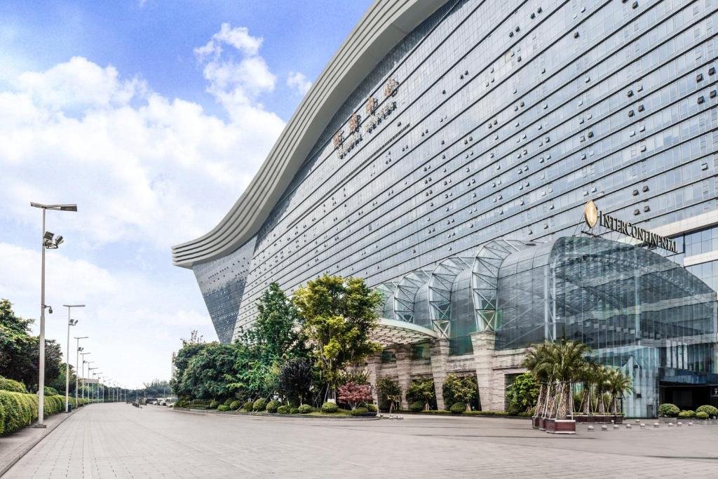 un gran edificio de cristal con un letrero de la calle delante de él en InterContinental Chengdu Global Center, an IHG Hotel, en Chengdú