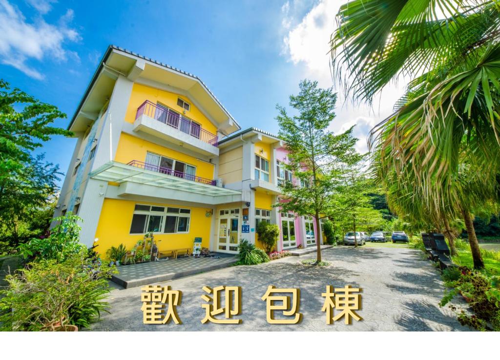 a yellow building with a sign in front of it at 光腳丫宜蘭民宿 in Dongshan