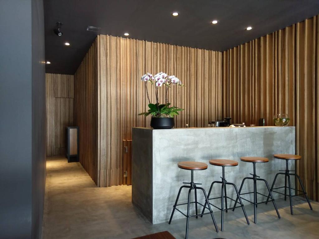 a lobby with a bar with stools and a vase of flowers at The 192 Inn in Ji'an