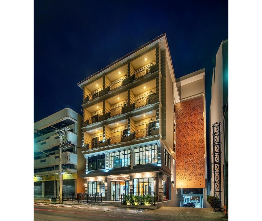 un edificio alto con balcones por la noche en Nine River Hotel en Ratchaburi