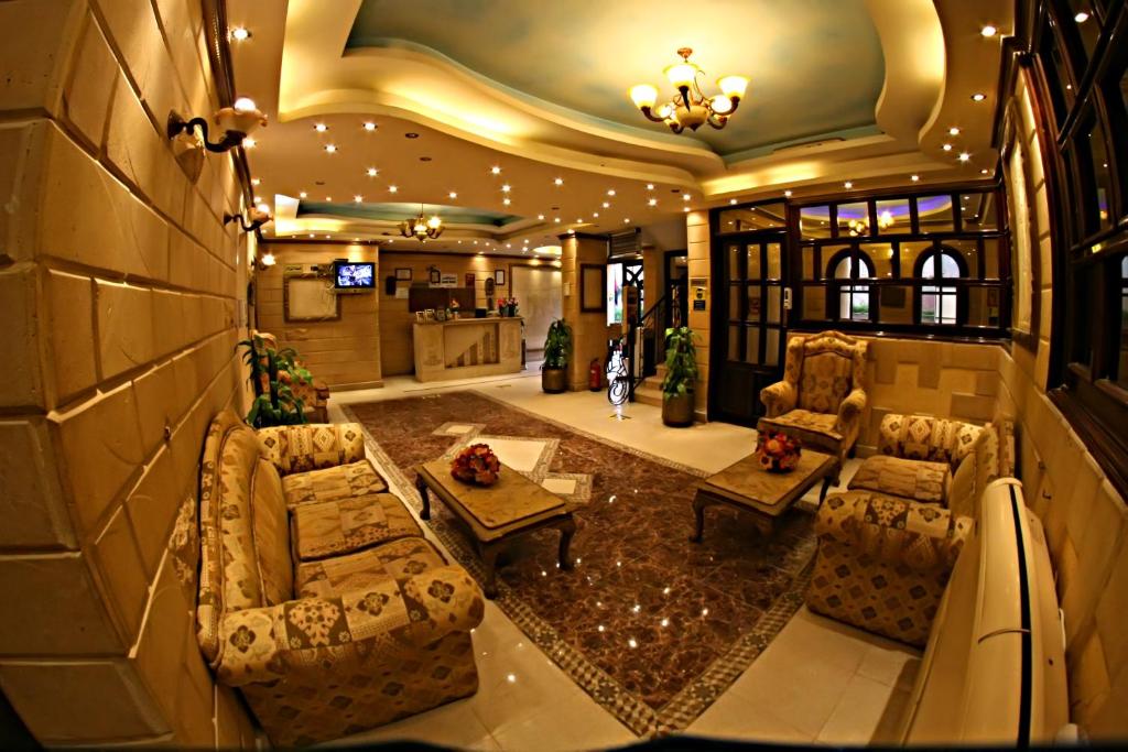 a living room with two couches and a table at Luxor Hotel Hurghada in Hurghada