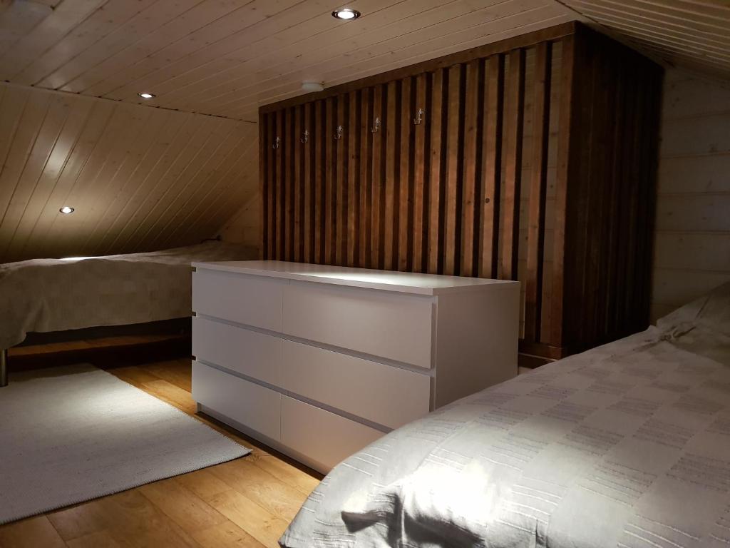 ein Schlafzimmer mit einem Bett und einer weißen Kommode in der Unterkunft Air-conditioned holiday home Vutnusmaja at Iso-Syöte in Syöte