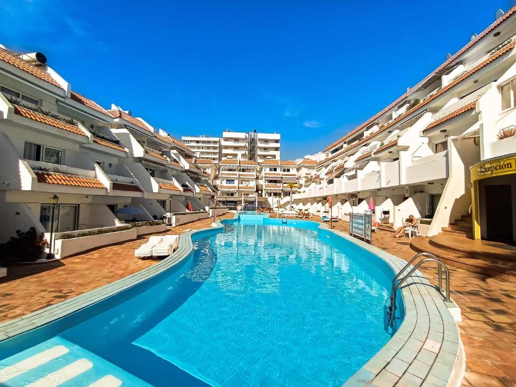 a large swimming pool in the middle of a building at Rentaliday Flor de Cia in Playa de las Americas