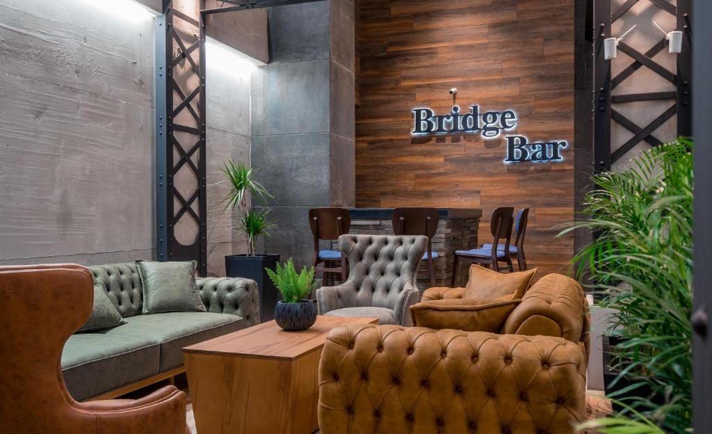 een bar met banken en stoelen en een tafel bij Bridge Hotel in Tbilisi City
