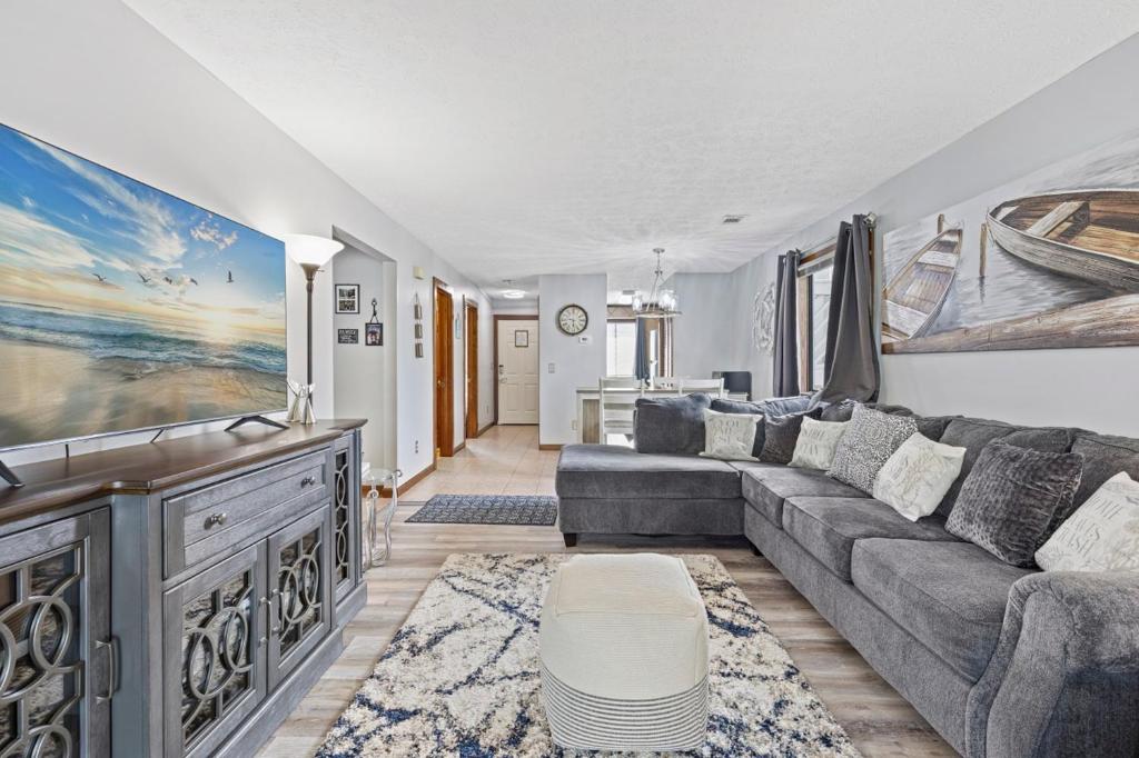 a living room with a couch and a tv at Spacious Modern Condo - 1st Floor - One Block to the Beach in Myrtle Beach