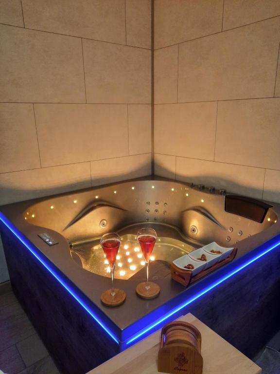a bathtub with two glasses of wine in it at R&M un moment de relaxation in Wardrecques