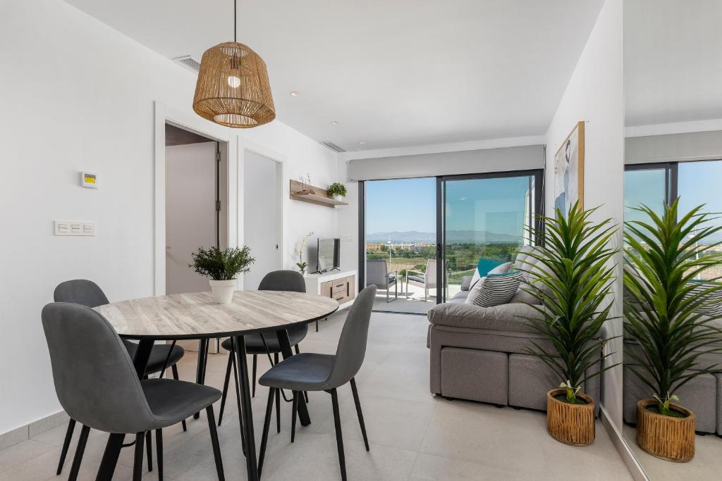 a dining room with a table and chairs and a couch at Apartamentos Benimar in Benijófar