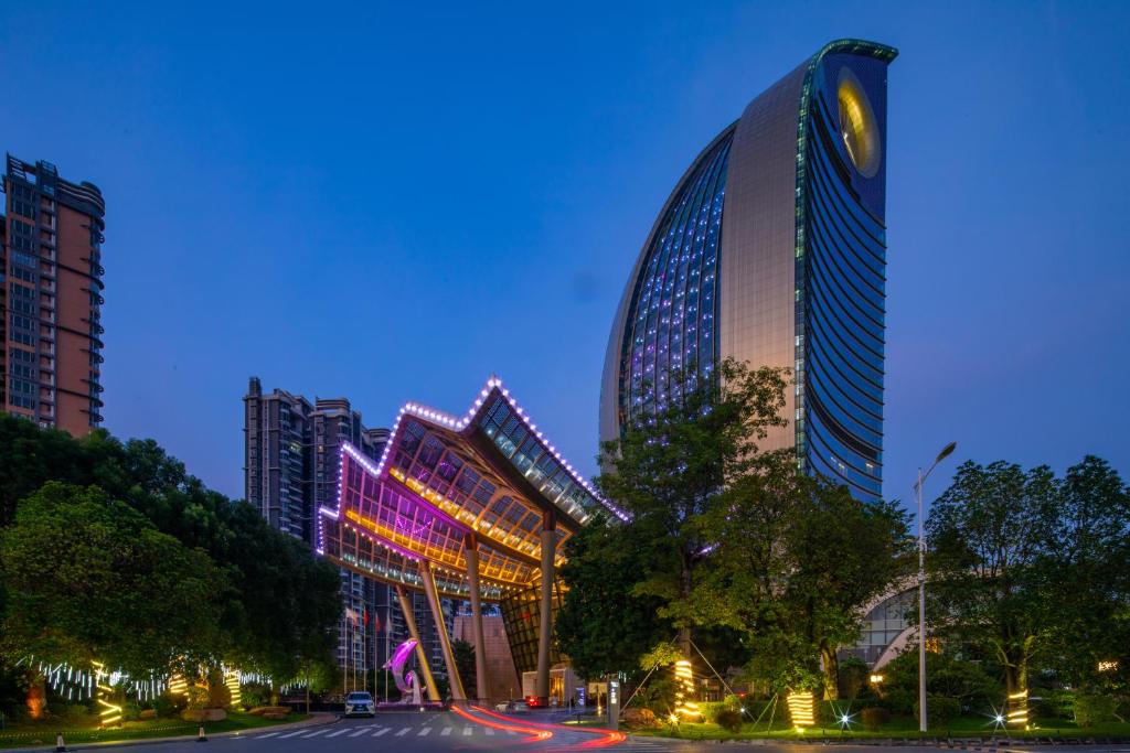 un grand bâtiment avec des lumières allumées la nuit dans l'établissement Wyndham Grand Foshan Gaoming, à Gaoming