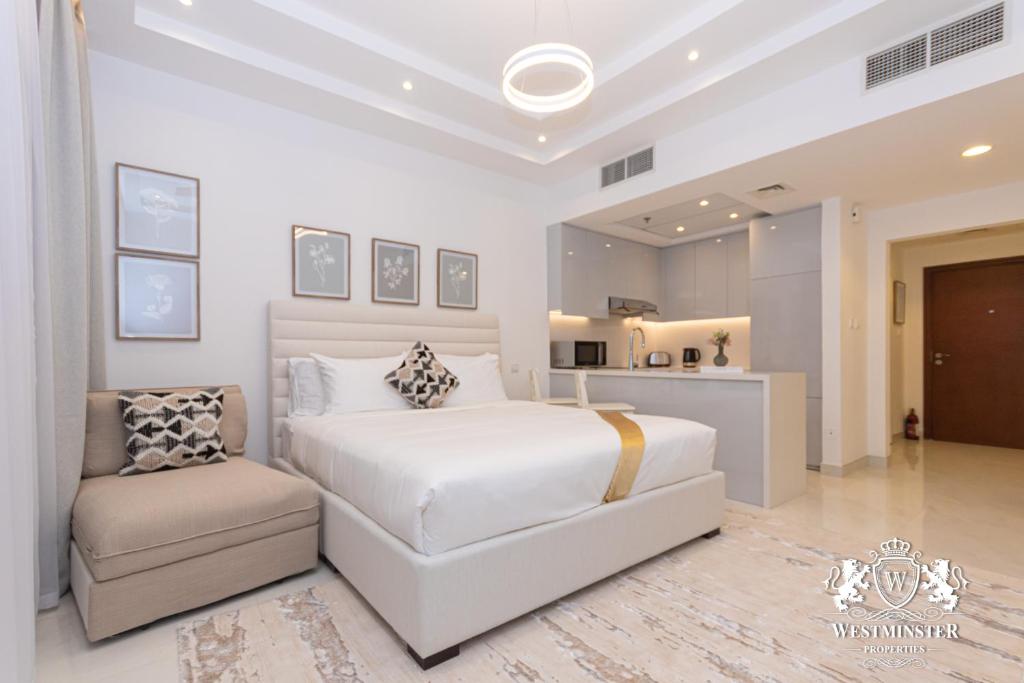 1 dormitorio blanco con 1 cama y 1 silla en Westminster Burj Al Nujoom en Dubái