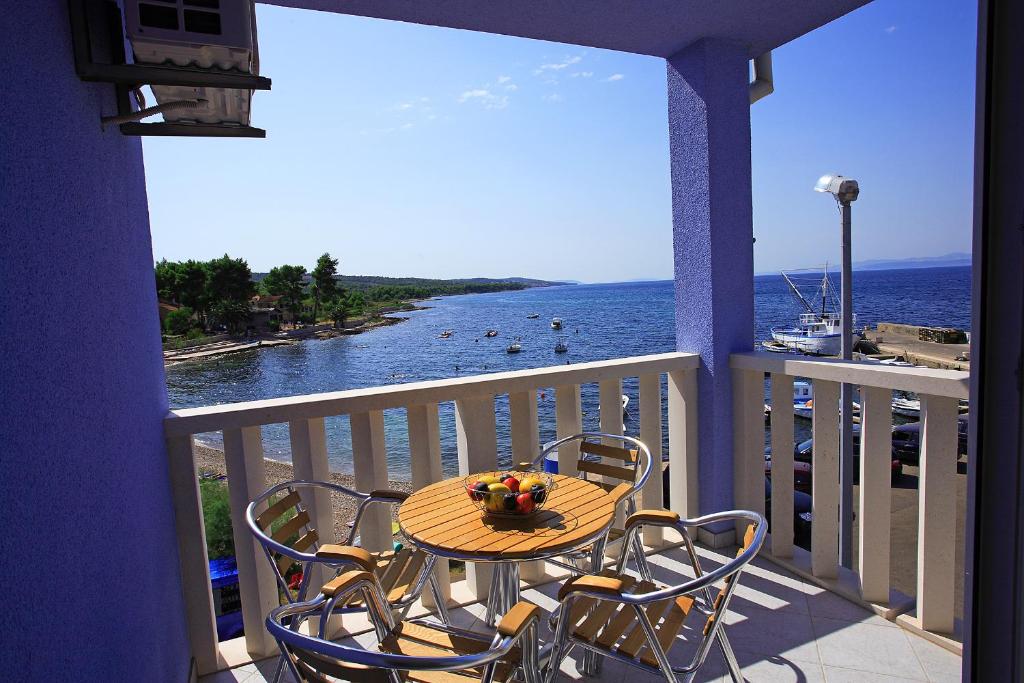 a table and chairs on a balcony with a view of the ocean at Aparthotel Marina Gromela in Mirce