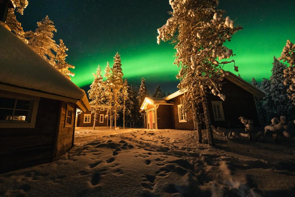 an aurora shines in the sky over a house at Arctic Sky Lapland in Saariselka