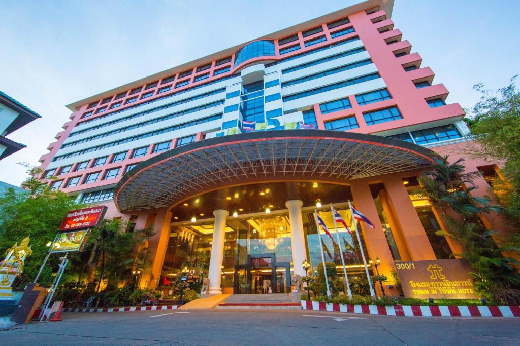 Town in Town Hotel Bangkok - SHA Plus في بانكوك: مبنى كبير أمامه أعلام