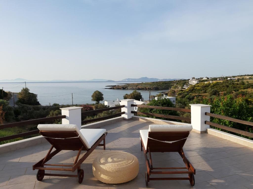 2 sillas en un balcón con vistas al océano en The Beach House Μουτσούνα Νάξος, en Moutsoúna