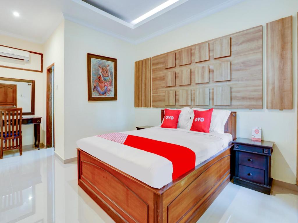 um quarto com uma cama grande e almofadas vermelhas em OYO 1762 Hotel Astiti Graha Tanah Lot em Tanah Lot