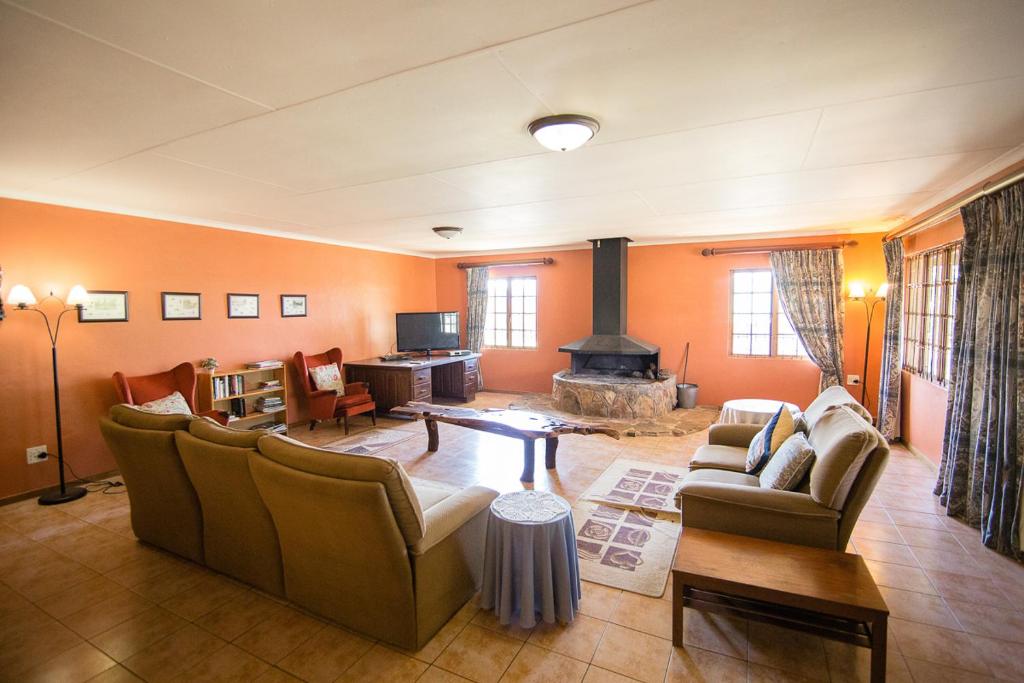 a living room with couches and a fireplace at Sneezewood in Dullstroom