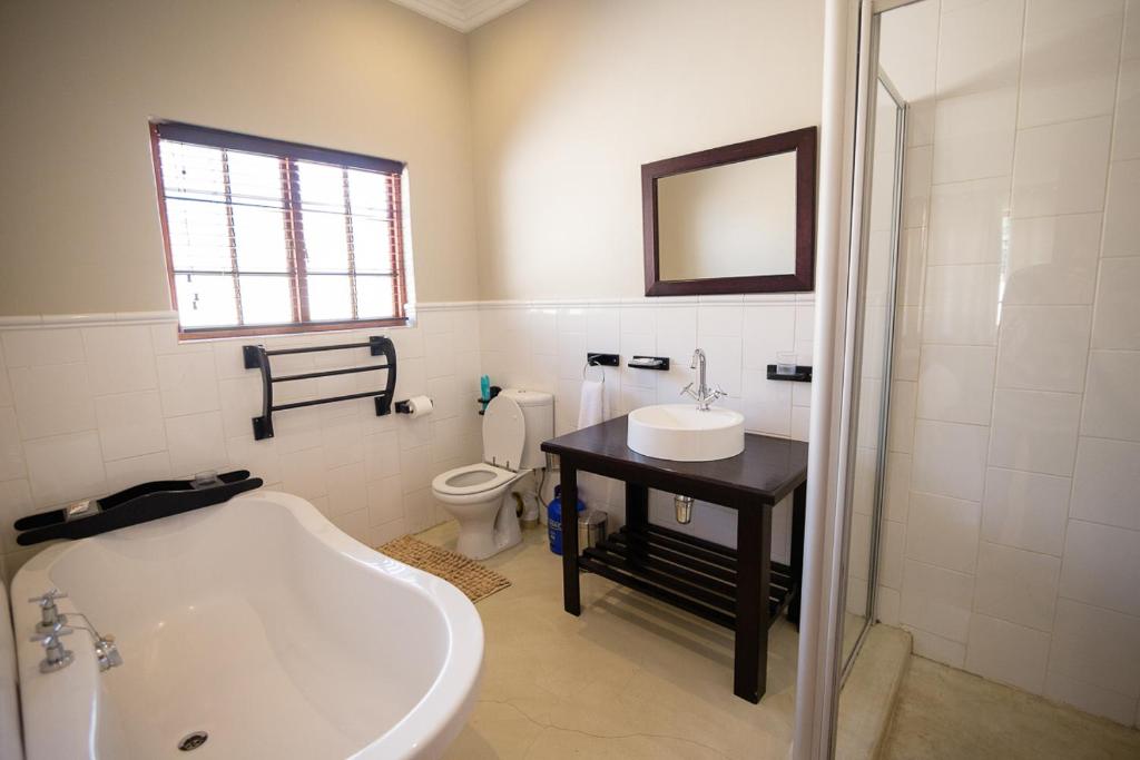 a bathroom with a tub and a sink and a toilet at Sorgenvrei in Dullstroom