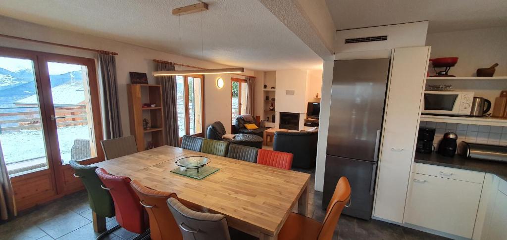 eine Küche und ein Esszimmer mit einem Holztisch und Stühlen in der Unterkunft Mont Bijou MOUNTAIN & QUIET chalet 10 pers by Alpvision Résidences in Veysonnaz